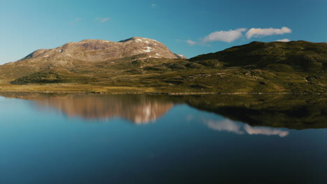 hermoso paisaje montañoso reflejado en el lago vavatnet en noruega - toma aérea