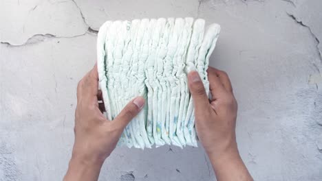 stack of baby diapers in hands