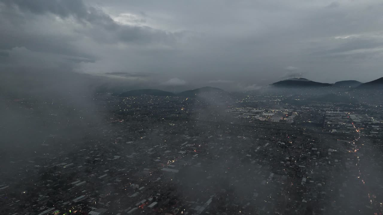 Drone flying among clouds above Ecatepec, Mexico
