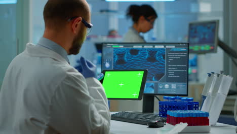 Researcher-holding-and-looking-at-tablet-with-chroma-key