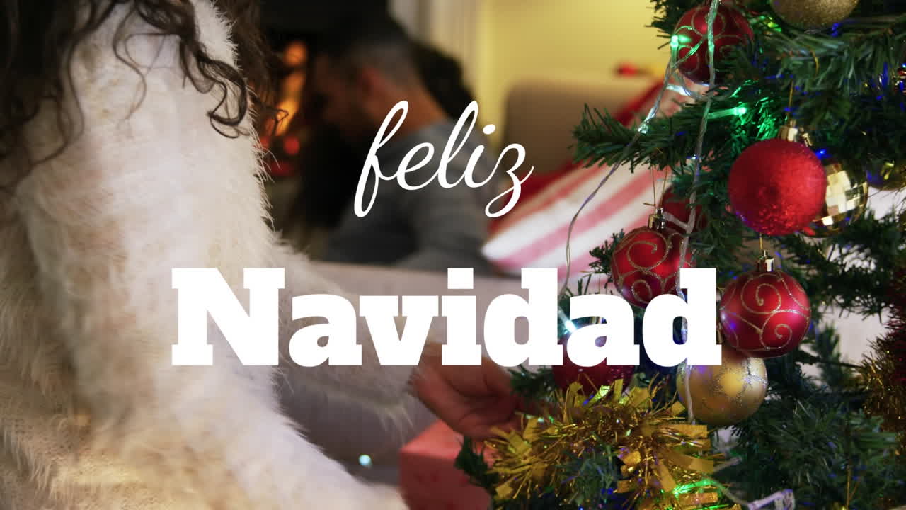 animación de navidad feliz navidad texto sobre mujer decorando árbol de navidad.
