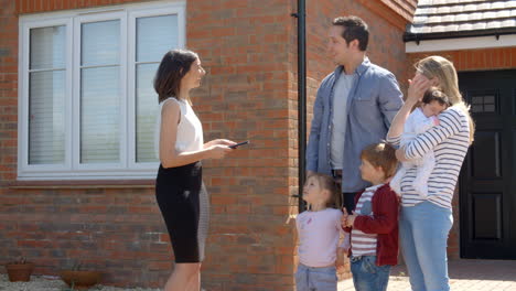 realtor outside house for sale with young family