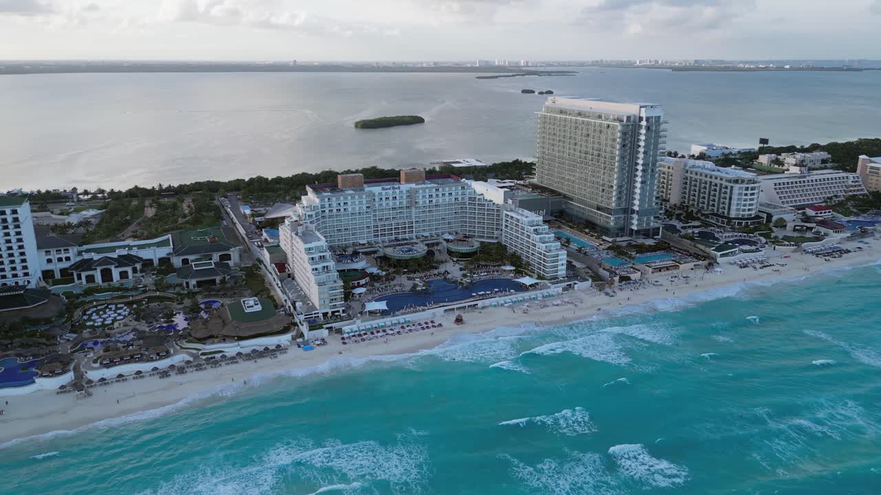 Sorvolo di hotel resort a Cancun, con la Laguna di Nichupté oltre la spiaggia di sabbia