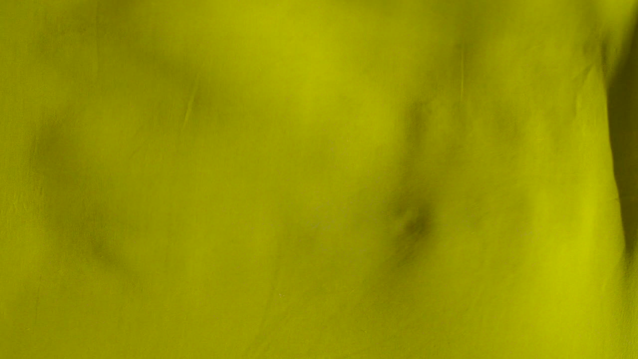 fondo de tela de satén de onda amarilla sin costuras \ tela de seda revoloteando en el viento de la tela ondulante