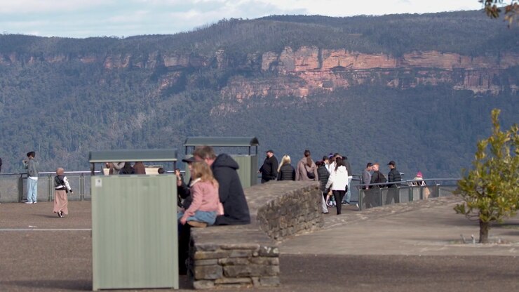 Visitors admire the vast valley and sandstone cliffs from Echo Point Lookout, Katoomba, Australia.