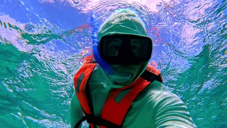 man snorkeling the surfaces of the caribbean sea