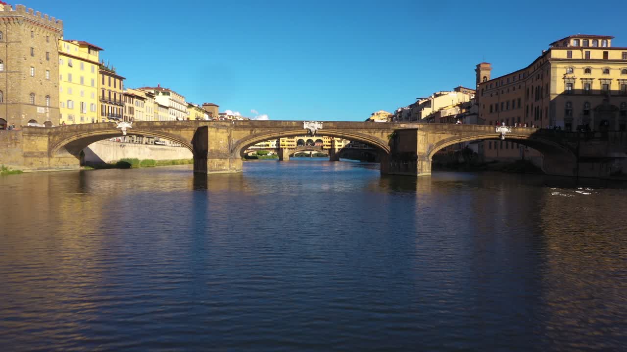 4k 이탈리아 피렌체의 화창한 날 다리 아래 아르노 강 위를 낮게 나는 공중 전망