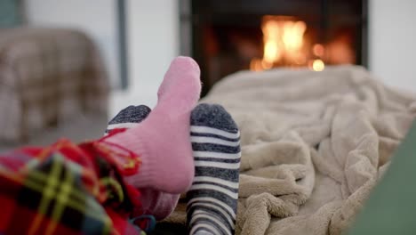 feet of couple in socks relaxing at home in front of open fire, slow motion