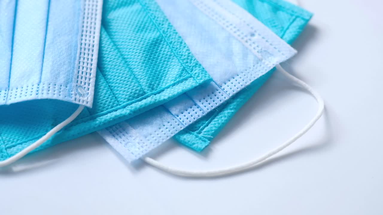 una pila de máscaras faciales desechables azules