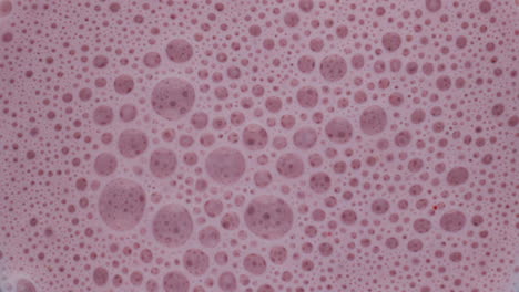 closeup burbujas de batido de bayas dentro de la licuadora. vista superior cóctel de frutas sabrosas.