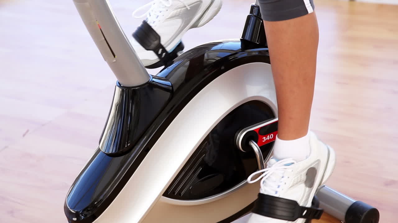 Mujer en forma haciendo ejercicio en bicicleta estática