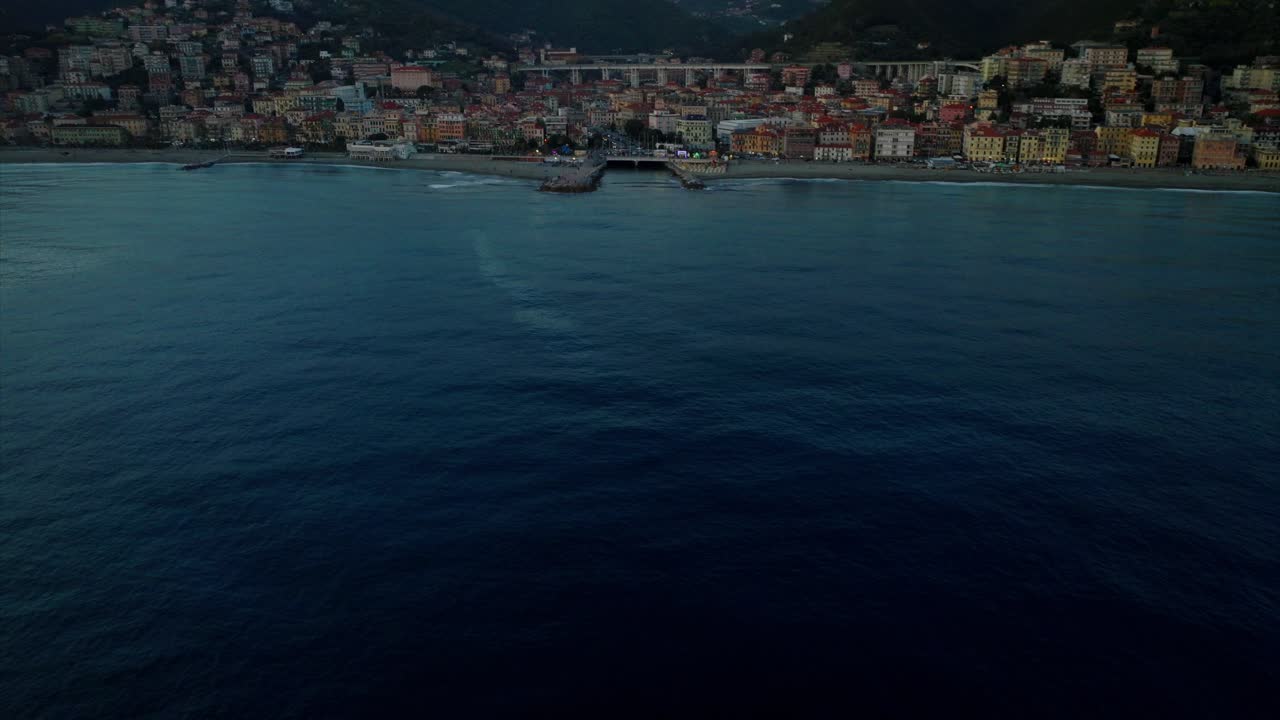 Avvicinamento cinematografico aereo della città di Varazze in Italia al tramonto