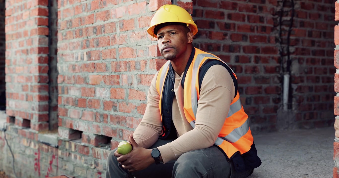 Construction Worker Taking a Break and Eating an Apple