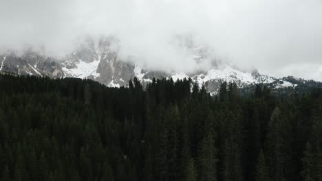 drone shot pushing towards a cloud covered dolomites in italy
