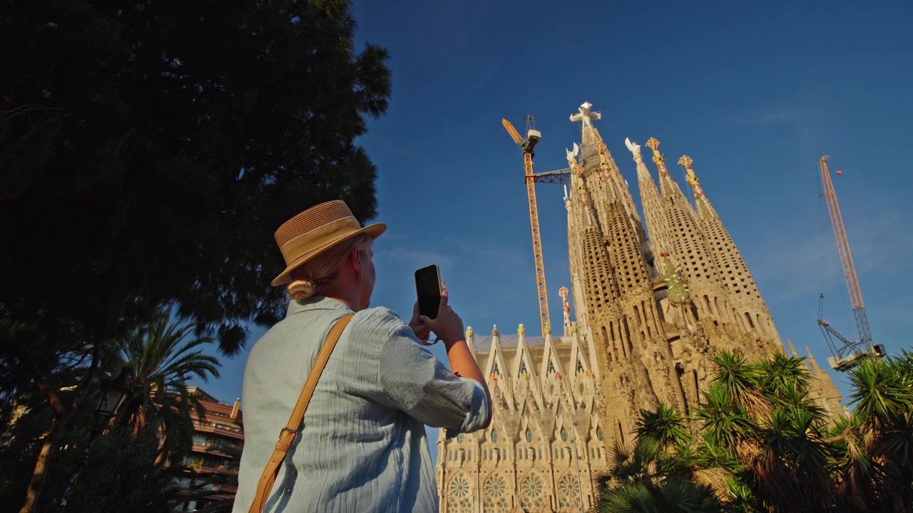 Donna turista che scatta una foto della Sagrada Familia a Barcellona