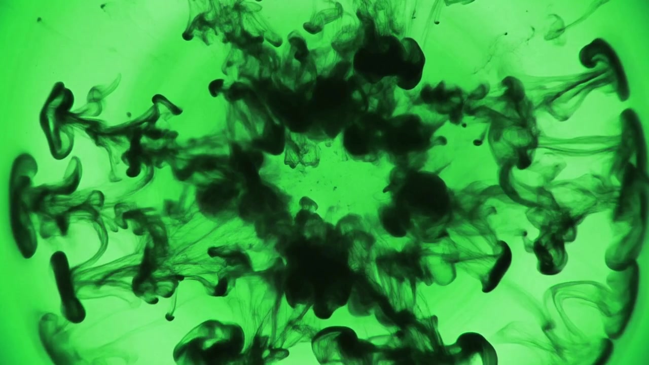 Inchiostro nero che gocciola e si espande in liquido verde
