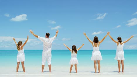 familia caucásica con ropa blanca en una playa tropical