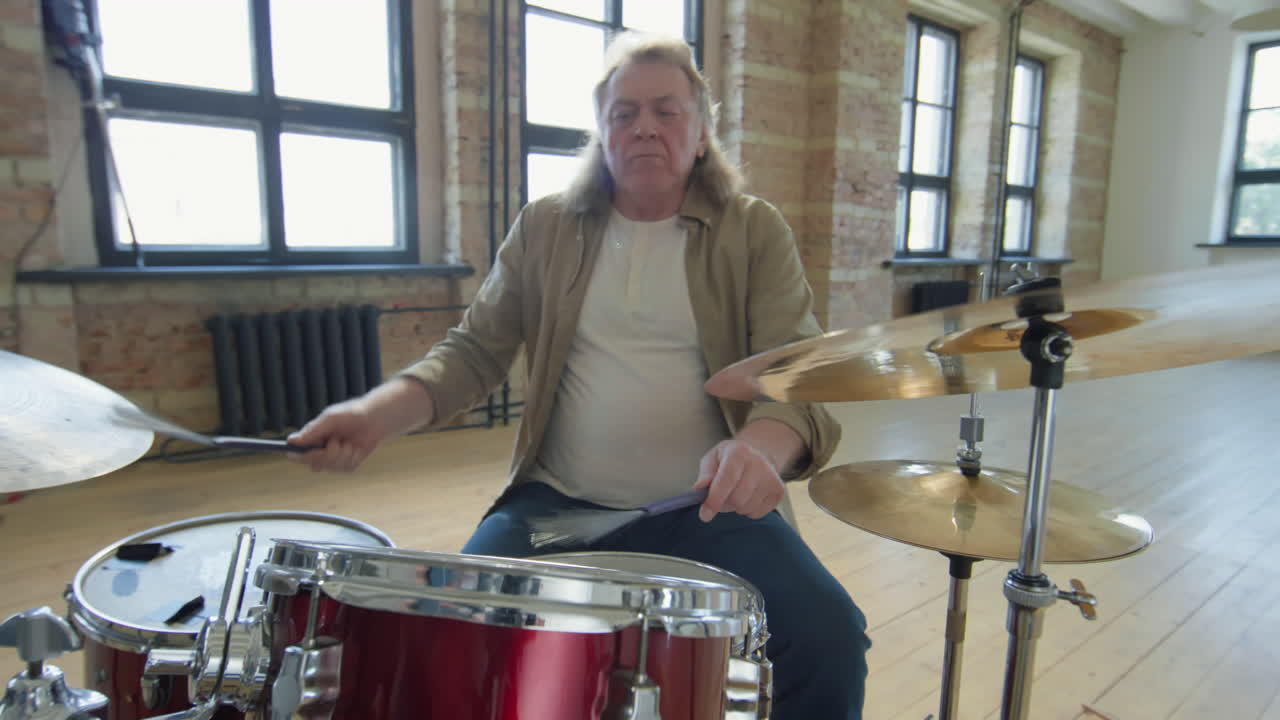 Senior Musician Drumming in Music Rehearsal Studio