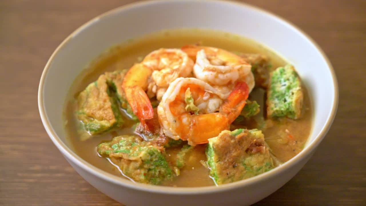 sopa agria hecha de pasta de tamarindo con gambas y tortilla de verduras - estilo de comida asiática