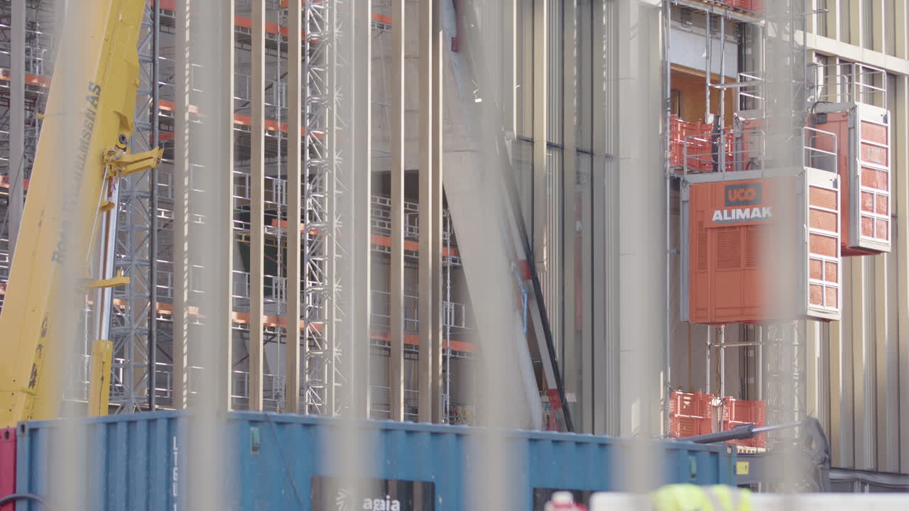 Blurred construction worker at a building site with scaffolding and crane