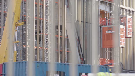 Blurred construction worker at a building site with scaffolding and crane
