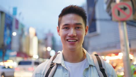 smiling asian man in city at night