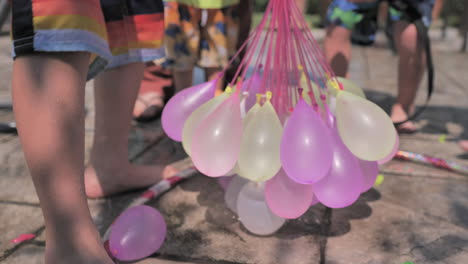 Static-slomo-shot-of-colorful-water-balloons-being-filled-on-sunny-day