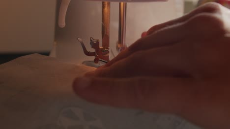 close up of slow moving hands and sewing machine needle