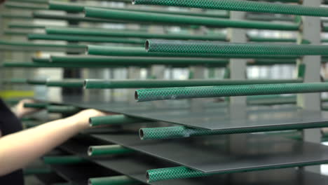 worker putting gray painted glass panels on the green shelve