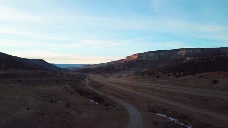 Drone-flying-upwards-revealing-roads-inbetween-mountains