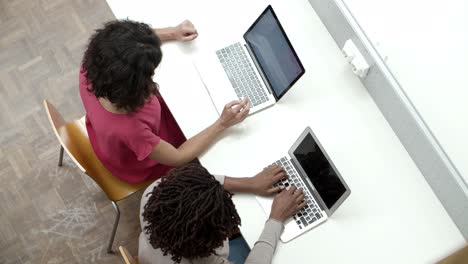 vista superior de mujeres que usan computadoras portátiles en la biblioteca