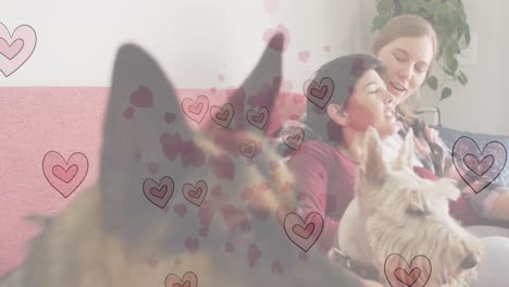 animation of heart emojis over happy caucasian female couple in love with dogs