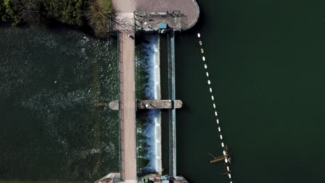 Majestic-river-flowing-into-a-dam-as-a-person-walks-across-bridge