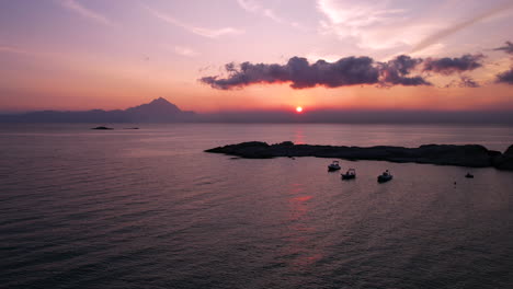 vista aérea del amanecer sobre el mar egeo y los barcos en la bahía en la costa griega, tomada por un dron