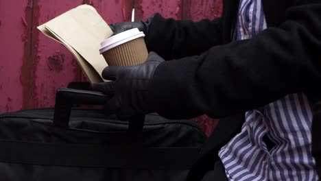 Business-woman-with-take-out-coffee-taking-out-documents-and-envelopes-in-briefcase-medium-shot