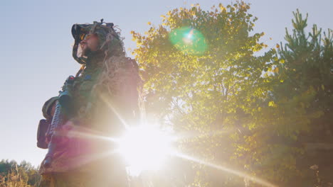 Hombre-En-Camuflaje-Con-Pistolas,-Debe-Ser-Contra-El-Cielo,-El-Sol-Brilla-En-Su-Pistola