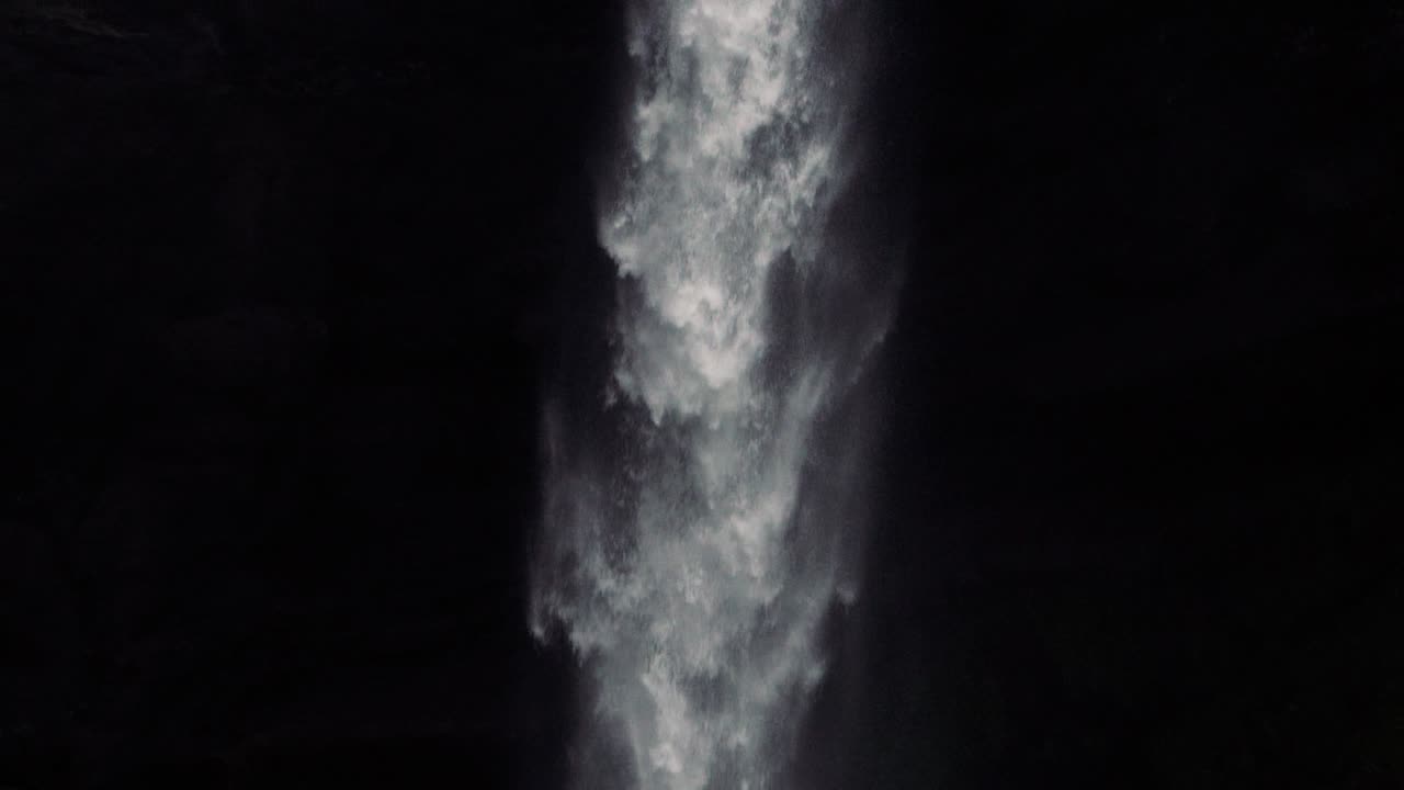 남자가 그것을 향해 걸어가는 원격 아이슬란드 폭포의 슬로우모션 샷