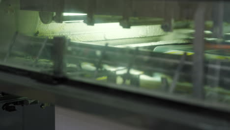 posters moving inside a high-speed industrial printer in a printing press. close up, slider shot