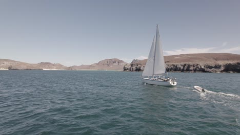 White-Yacht-Cruising-In-Serene-Waters-On-A-Beautiful-Day---aerial-shot