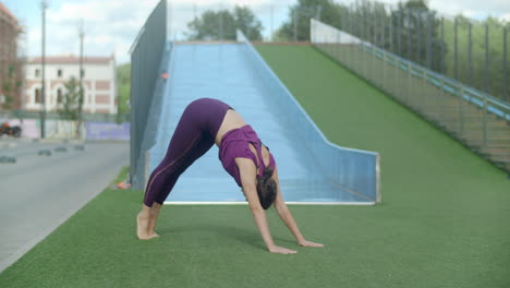 woman practicing yoga plank in a park