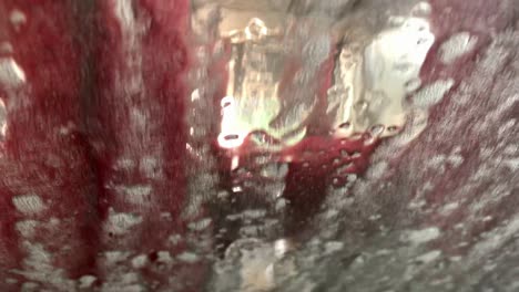self-serve car wash: red soap and suds perspective