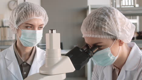 científicos trabajando con un microscopio en un laboratorio