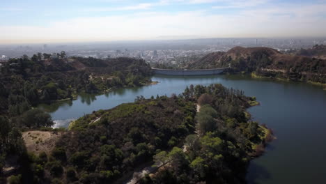 aerial shot circling around hollywood lake and hollywood barrage, with downtown los angeles in the background