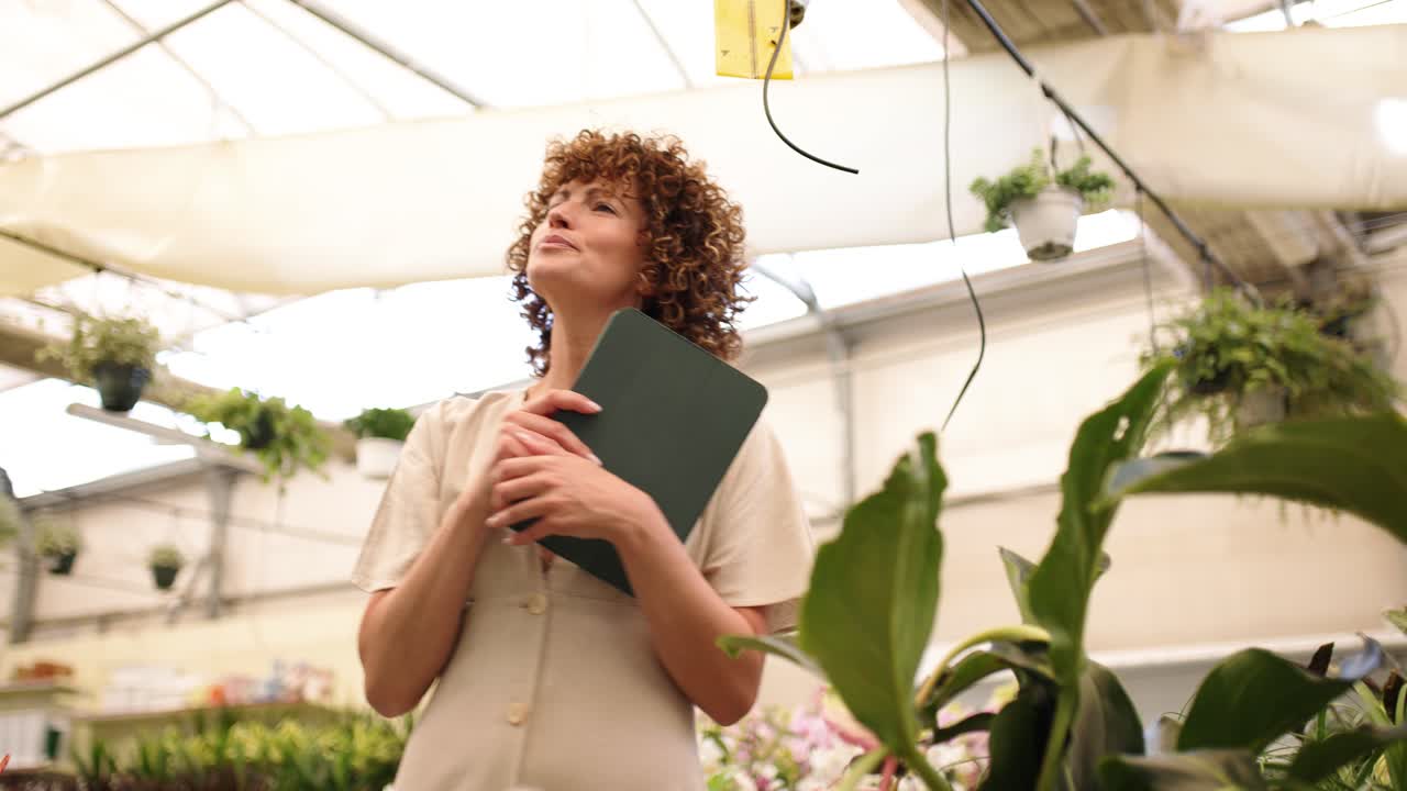 Female entrepreneur managing plants in greenhouse