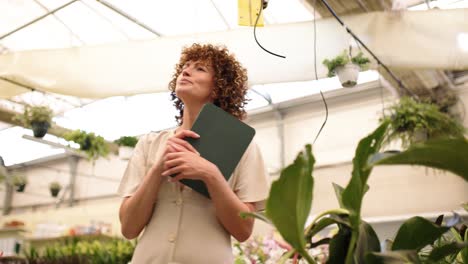 female entrepreneur managing plants in greenhouse