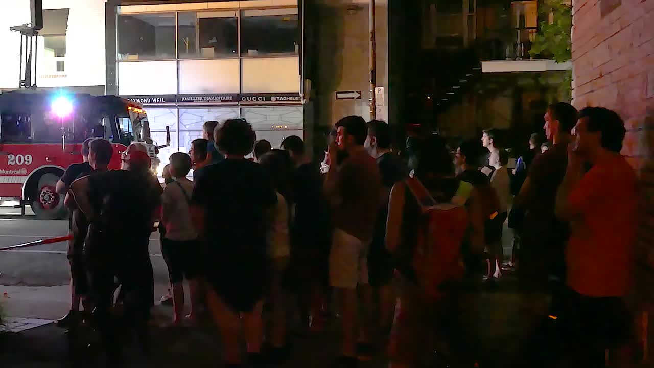 onlookers and residents gather to watch Lajeunesse Street apartment blaze destroy an apartment complex in Montréal, Québec, Canada