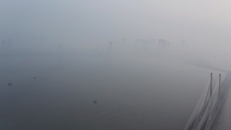 dolly back drone shot of mahim bay mumbai sealink bridge on a hazy polluted day