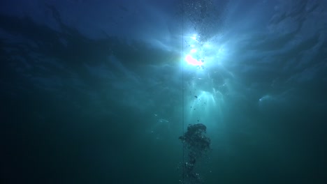 Aufsteigende-Linie,-Die-Zur-Meeresoberfläche-Führt,-Während-Sonnenstrahlen-über-Das-Wasser-Strömen