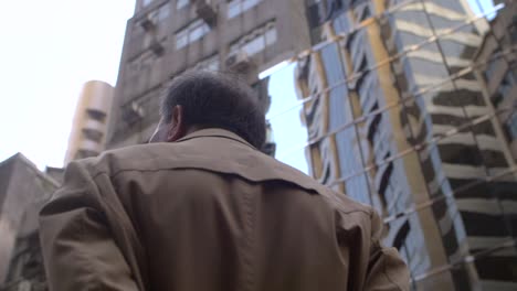 man in a jacket by a skyscraper