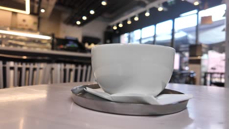 white coffee cup on table in a cozy cafe